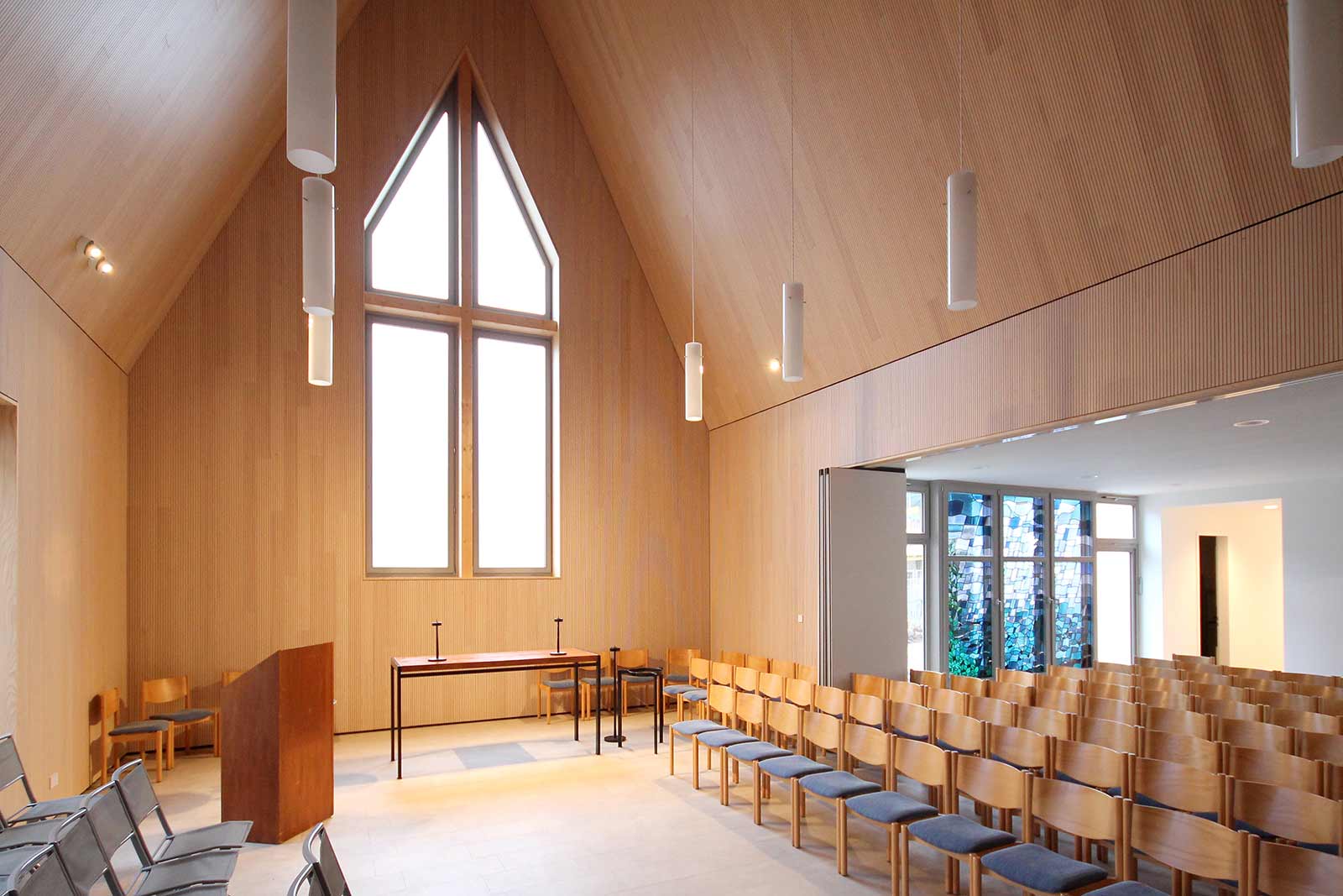 Kirchenraum mit Bestuhlung – Kirchliches Gemeindezentrum Hasloh Der Baustoff Holz überzeugt nicht nur für Fassaden sondern auch für den Kircheninnenraum und sorgt für gute Dämmung und hervorragende Akustik.