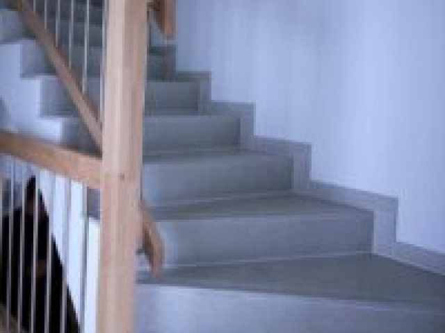 Treppenhaus mit Handlauf aus Buchenholz im Neubau eines Mehrfamilienhauses mit 10 Wohnungen