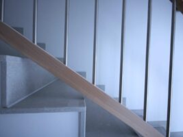 Treppenhaus mit Handlauf aus Buchenholz im Neubau eines Mehrfamilienhauses mit 10 Wohnungen