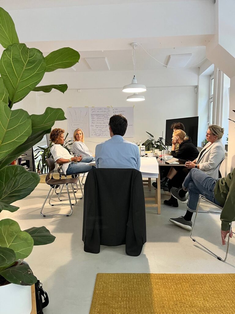 Das Team von Stadtblick Architekten im hellen Besprechungsraum in Hamburg.