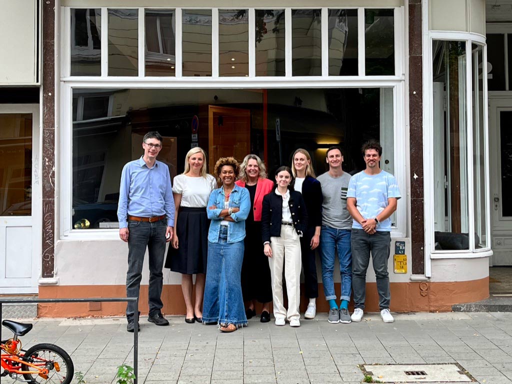 Das Team von Stadtblick Architekten vor dem Büroschaufenster in Hamburg.